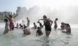 Parisians and tourists, adults and children alike, bathe in the large pool of the Trocader...