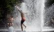 Children play in water jets in a public fountain in Toulouse during the heatwave. An inten...