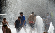 Children play in water jets in a public fountain in Toulouse during the heatwave. An inten...