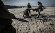 Cadets carry used rocket cartridges during firing training with SPG recoilless guns and Ka...