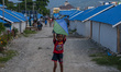 A child of a disaster victim plays a kite near the refugee camp at the Lere shelter, Palu,...