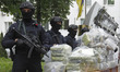 Ukrainian police officers stand guard in front of bags of cocaine seized during a special...