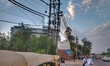 A man waits for the cab as power lines are seen behind him in New Delhi, India, on 3 July...