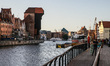 Young people walking on the Motlawa river bank in front of  tenement houses on the Wyspa S...