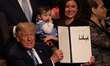 U.S. President Donald Trump holds up his signed executive order on advancing American kidn...
