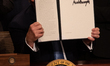 U.S. President Donald Trump holds up his signed executive order on advancing American kidn...