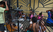 A group of residents seen playing cards and bingo on top of tombs inside the Manila North...