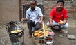 A customer eats Samosa from a road side vendor in Old Delhi, India, on 20 July 2019. 
