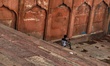 A boy uses his mobile phone on the stairs of Jama Masjid in Old Delhi, India, on 20 July 2...