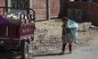 A little girl walks with a bag of waste on the streets of Mokattam (the garbage city of Ca...