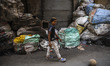 A guy play football in front of a pile of waste in the street of Mokattam (the garbage cit...