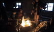 Afghan migrants warm themselves by a fire on the second story of an  abandoned brick facto...