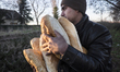 A young migrant receives bread donations from Pastor Tibor Vargo, a protestant minister fr...