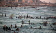 Palestinians swim in the Mediterranean sea during hot weather in Gaza City on August 16, 2...