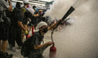 A Protester is seen spraying a fire extinguisher inside an MTR station in Hong Kong on Aug...