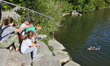 Man testing a homemade remote-controlled boat (that floats by using plastic water bottles)...