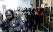 French policemen face demonstrators on the Champs Elysées avenue during an anti-government...