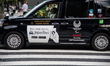 Taxi with signs of Tokyo Olympic games 2020 in the city center of Tokyo near Tokyo tower....