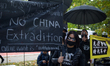 Demonstrators are seen holding banners and umbrellas during a rally against Chinese govern...