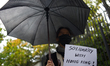 A demonstrator holds a sign during a rally against Chinese Government on September 29, 201...