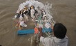 Hindu goddess Durga into the Ganges river   during the immersion ceremony of Durga Puja, i...