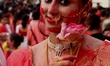 An Indian Hindu devotee smiles as she is smeared with vermillion powder as part of a ritua...