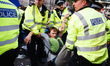 Police officers arrest a member of climate change activist movement Extinction Rebellion (...