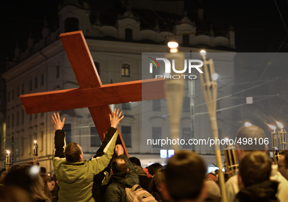 People carry the Cross in front of the controversial striptiz club during the Way of the Cross 'There is a worst SMOG' presided by Cardinal...