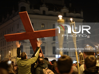 People carry the Cross in front of the controversial striptiz club during the Way of the Cross 'There is a worst SMOG' presided by Cardinal...