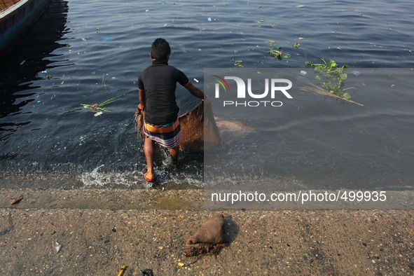 A man is washing a sack used for carrying vegetable at the bank of river Buriganga, Dhaka, Bangladesh, 24 March, 2015. 
