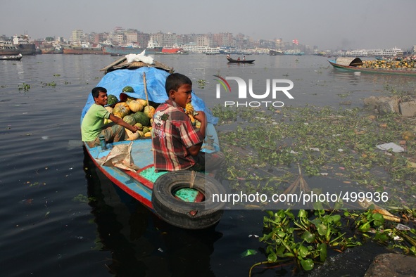 A child laborer is eating fruit taken from the dumped fruits at the bank of river Buriganga, Dhaka, Bangladesh, 24 March, 2015. 