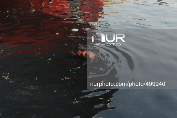 A man is shaving bath in the toxic water of Buriganga at the bank of river Buriganga, Dhaka, Bangladesh, 24 March, 2015. 