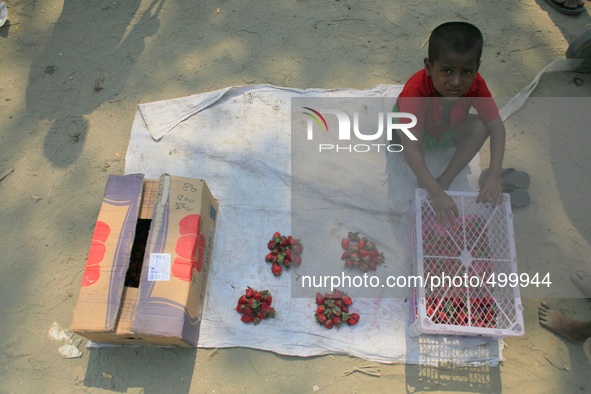 A child laborer is selling fruits taken from dumped fruits at the bank of river Buriganga, Dhaka, Bangladesh, 24 March, 2015. 