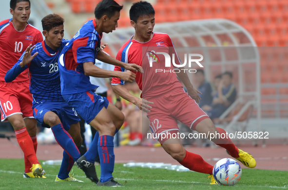 Ri Hyong Jin of DPR Korea (R) is closed down by Cambodia players during the AFC U-23 Championship 2016 qualifiers round at Rajamangala Stadi...