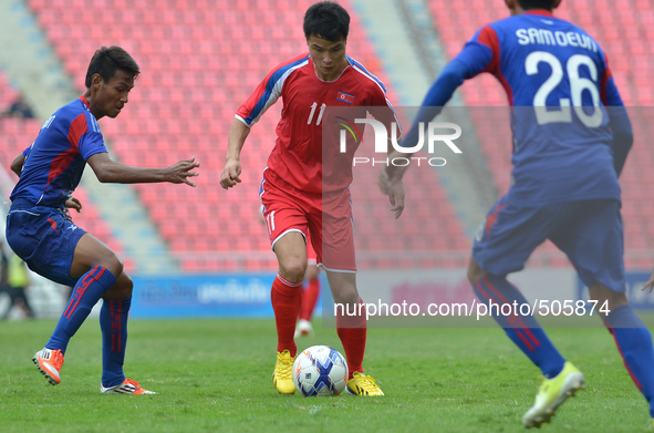 Jang Ok Chol of DPR Korea (C) is closed down by Cambodia players during the AFC U-23 Championship 2016 qualifiers round at Rajamangala Stadi...