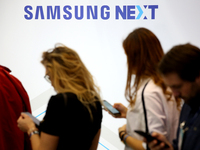 The Samsung logo is pictured as people check the phones during the annual Web Summit technology conference in Lisbon, Portugal on November 6...