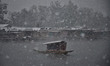 A Kashmiri boatman rows his boat as valley receives the seasons first snowfall in Dal Lake...