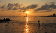 A man is silhouetted as he walks along the shores of the Arabian Sea in Mumbai, India on 0...