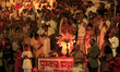A Hindu priest holds a traditional lamp as he performs evening prayers called ''Maha Aarti...