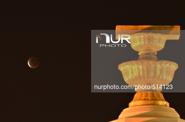 A moon is seen over the Democracy Monument during a total lunar eclipse in Bangkok, Thailand on April 4, 2015. 
