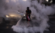A anti-government demonstrator sprays a fire extinguisher  during protest in Santiago, Chi...