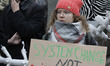 A climate activist holds a placard reading like 'System change not climate change' during...