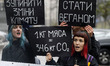 Climate demonstrators hold placards reading like '1 kg of meat = 34,6 kg CO2', 'Stop clima...