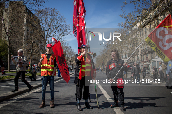 Three demonstrators holding cgt and antifa flags during a protest as part of a national mobilization against the government's austerity meas...