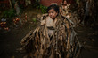 Religious devotees, dressed in dried banana leaves and covered in mud, during a holy Mass,...