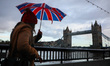 People are walking in the rain towards Tower Bridge in London, United Kingdom on 11 Decemb...