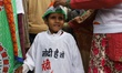 A woman adjusts the congress printed cap of his son before taking part in the rally 'Bhara...