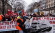A striking railroad worker chants slogans in a megaphone in front of the train procession...