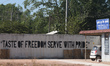 'Taste Of Freedom Serve With Pride' inscription on a wall seen on the roadside between Dar...