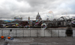 A man blows bubbles as people walk by, outside the Tate Modern gallery, in the south bank...